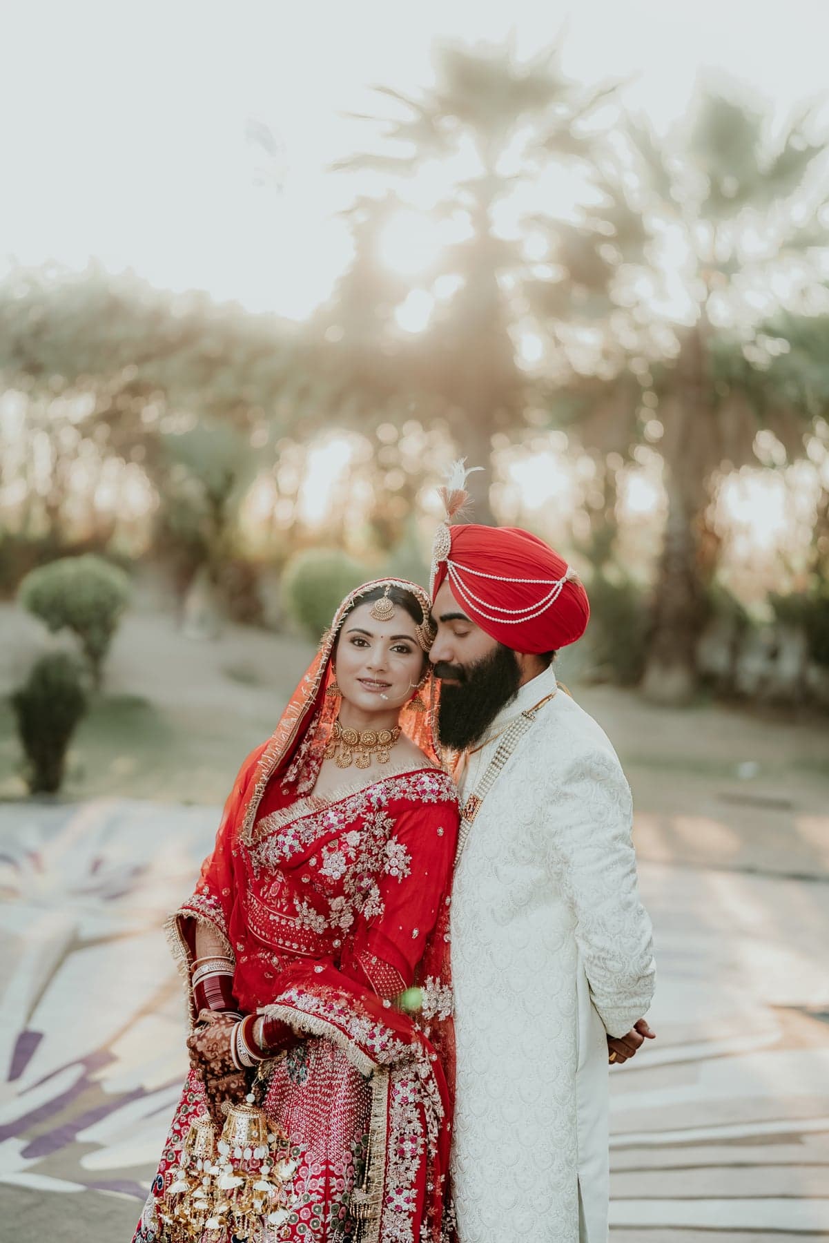 A couple embracing beneath palm trees at golden hour
